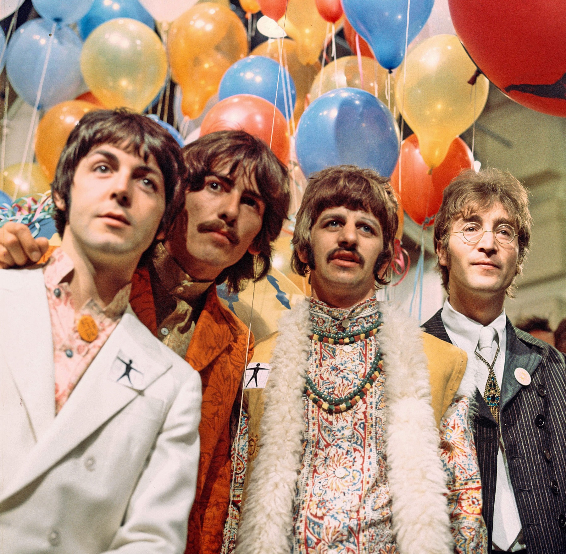 The Beatles surrounded by colorful balloons.