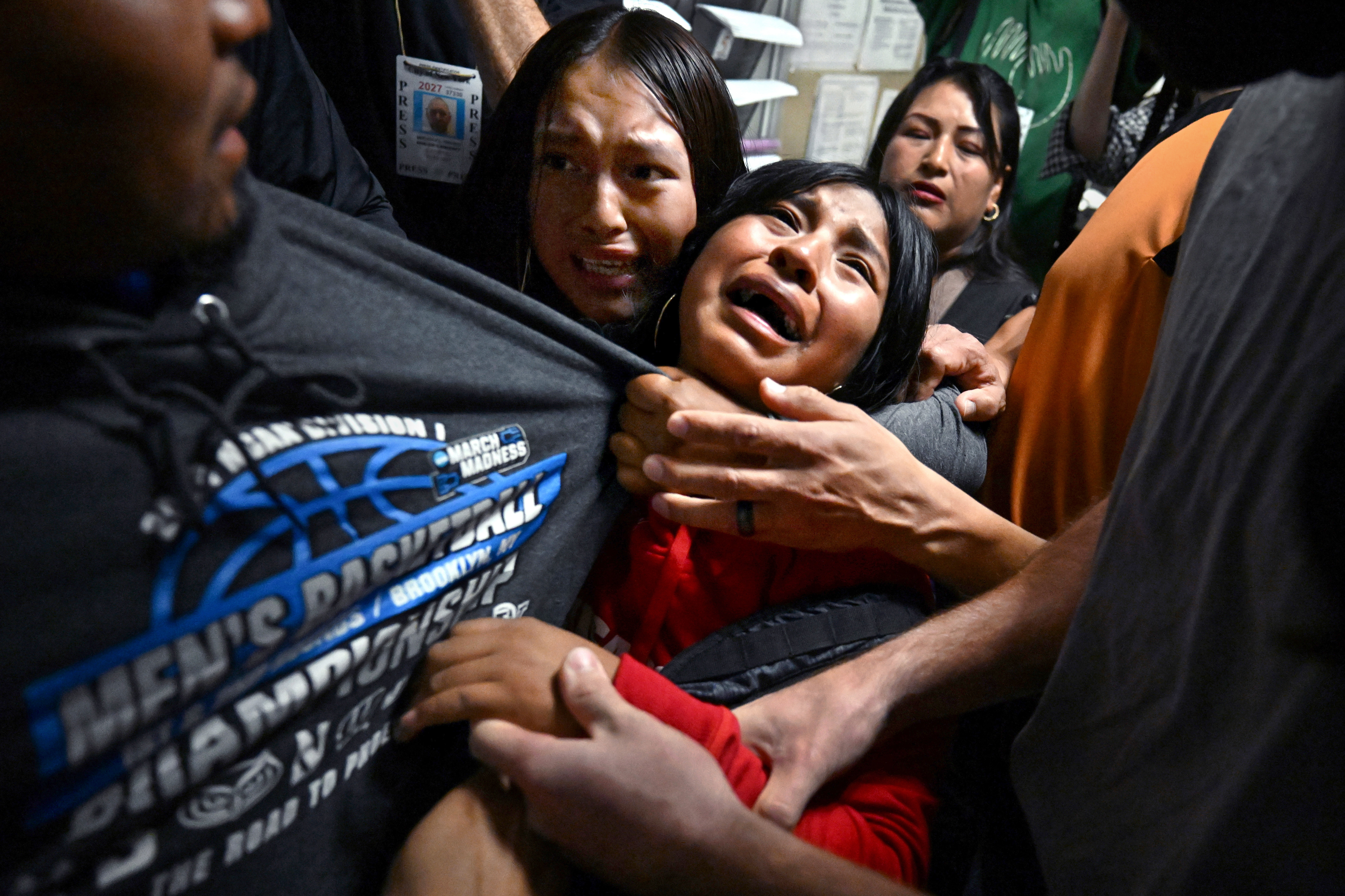Young girls embrace a loved one detained after an immigration court hearing.